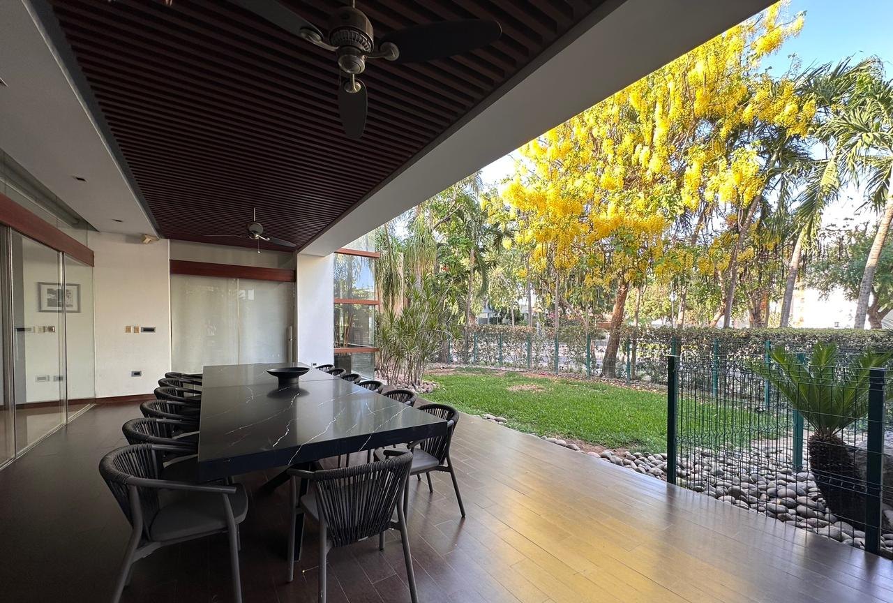 Terraza cubierta con comedor exterior y jardín